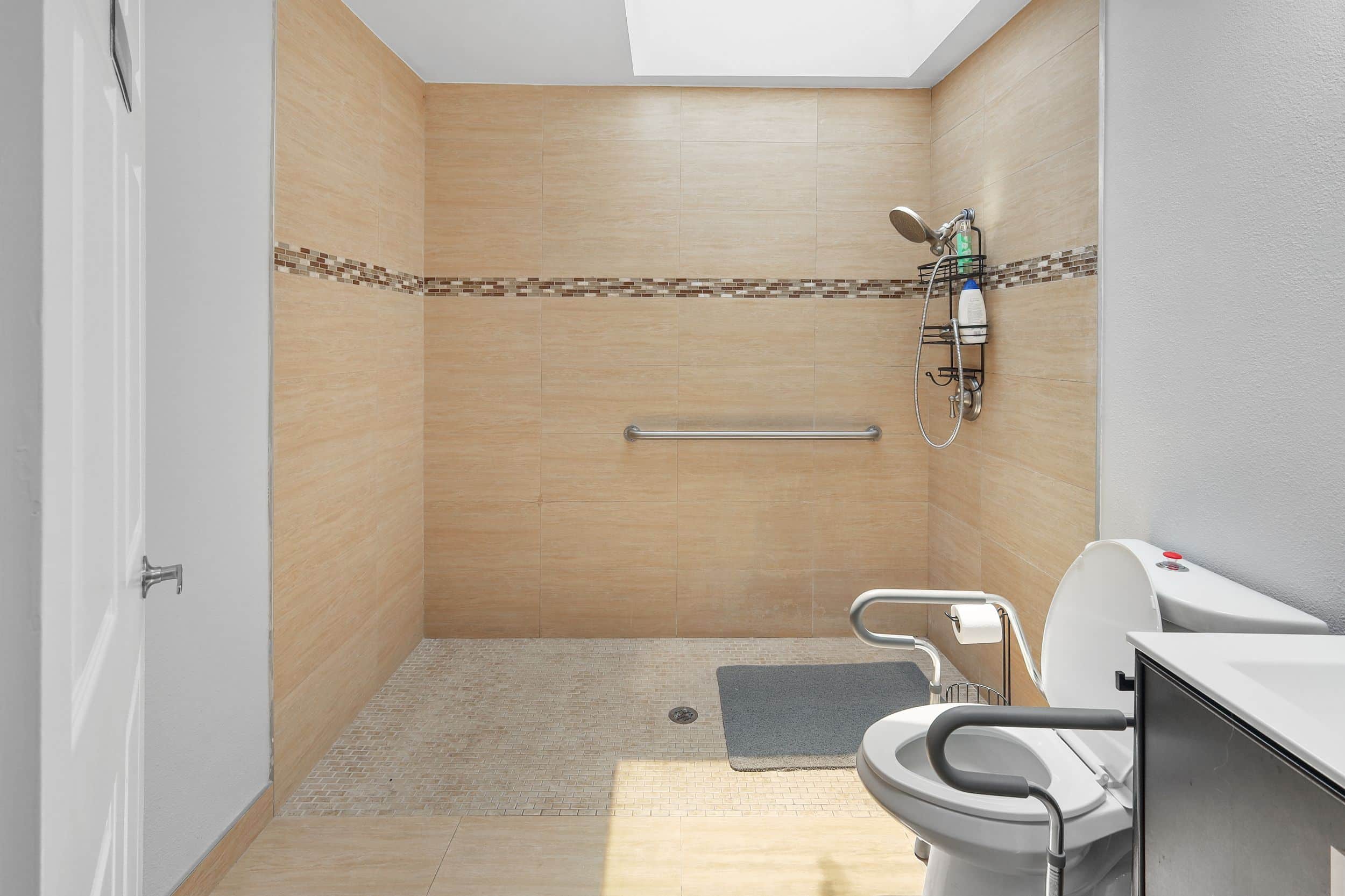 Accessible bathroom with walk-in shower, grab bar, and toilet featuring a soft-close lid.